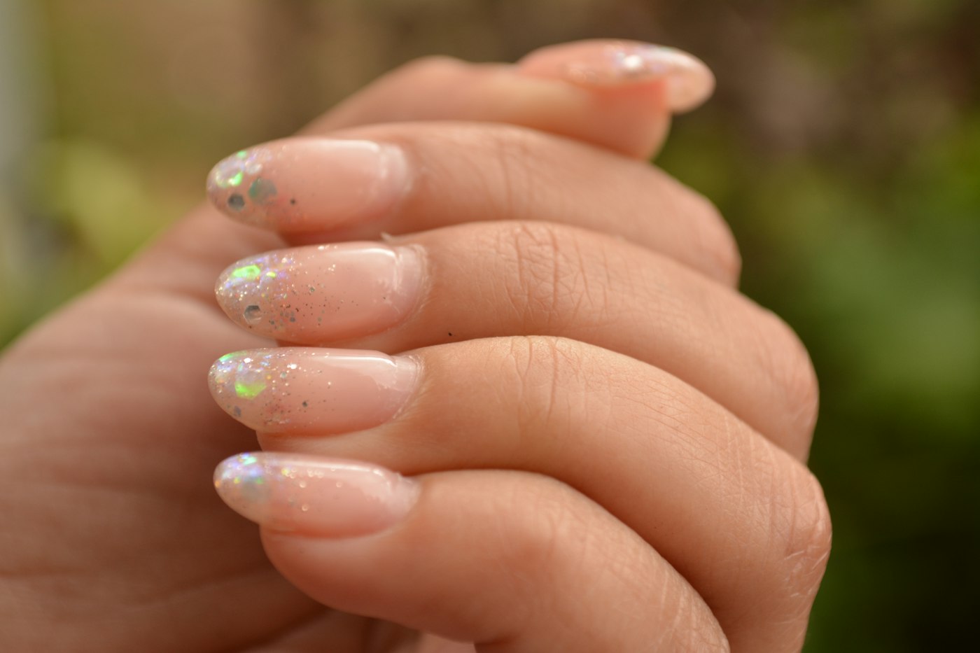 Sheer pink nails with iridescent glitter