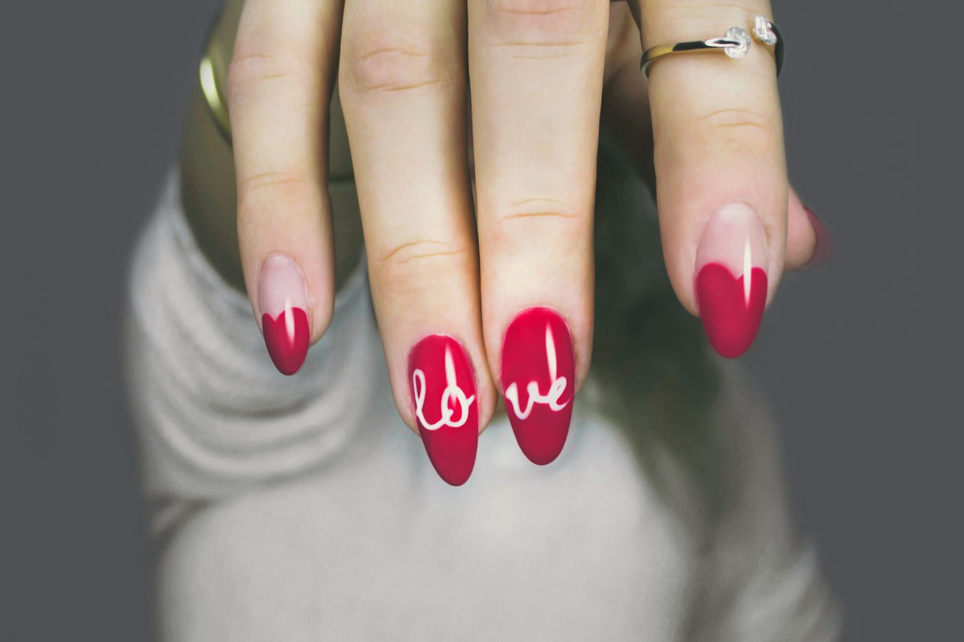 Red manicure with a heart tip and script lettering