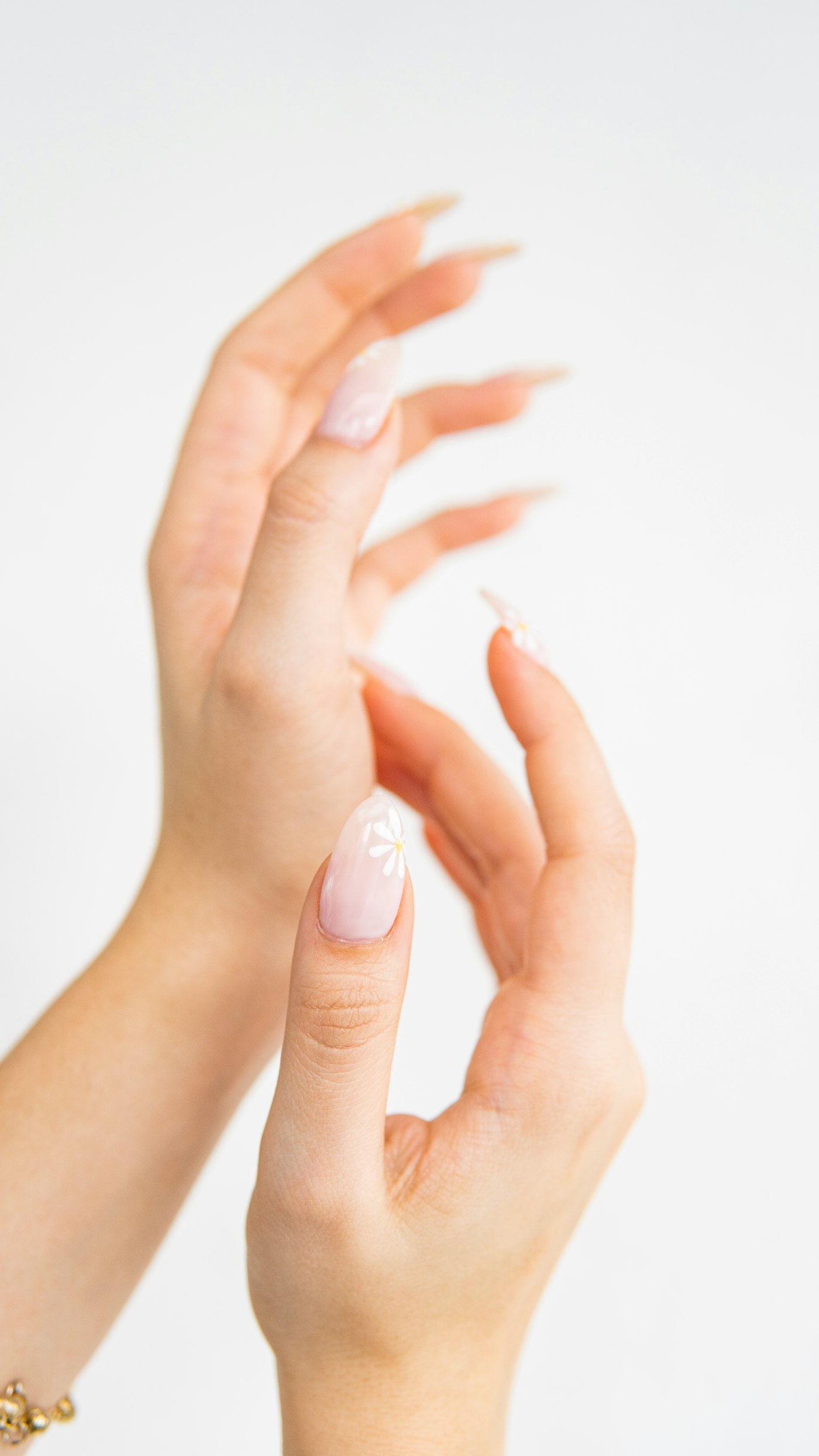 Soft pink nails with a small daisy
